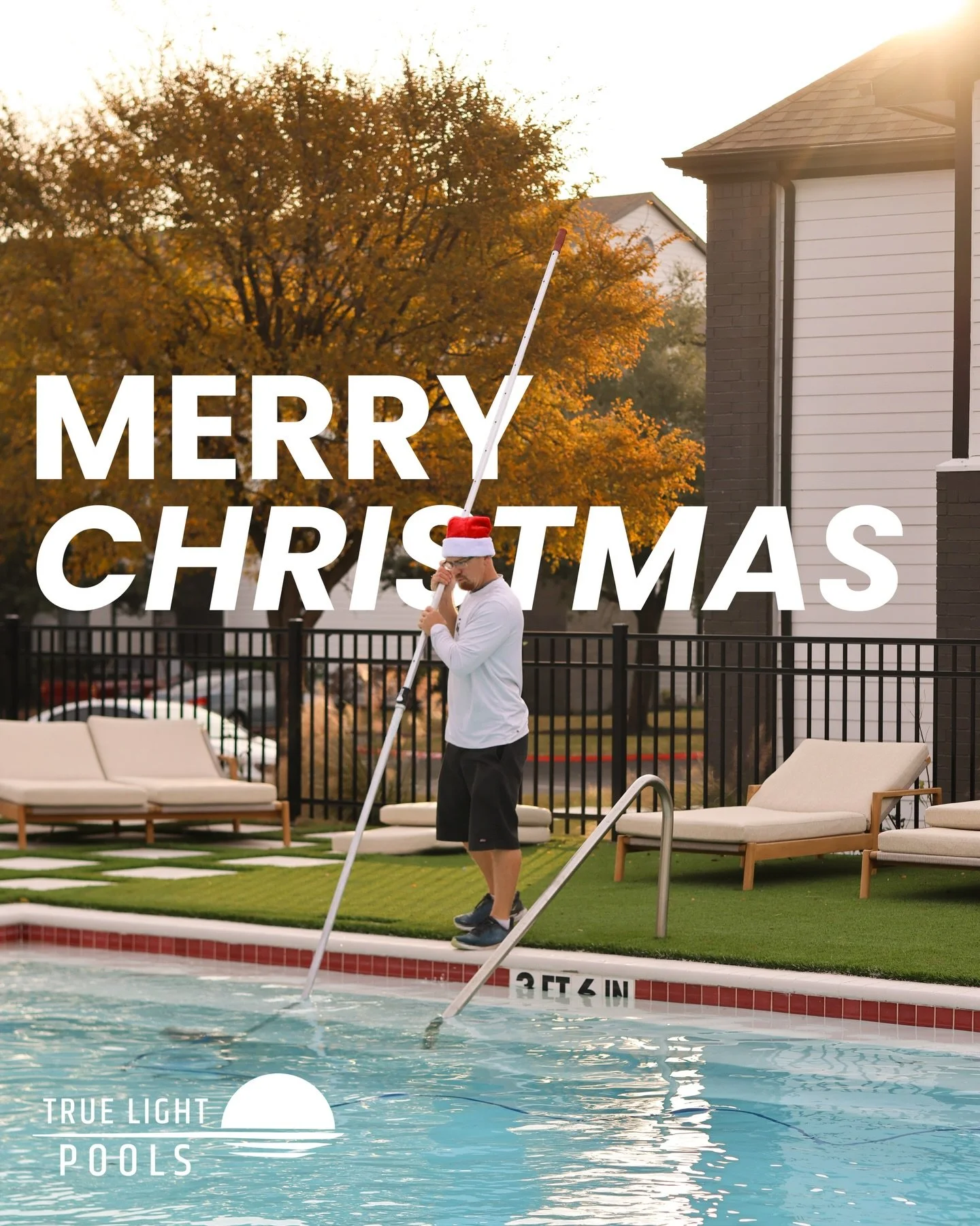 Pool technician in Santa hat cleaning pool with pole, "Merry Christmas" text overlay, True Light Pools branding, autumn foliage in background.